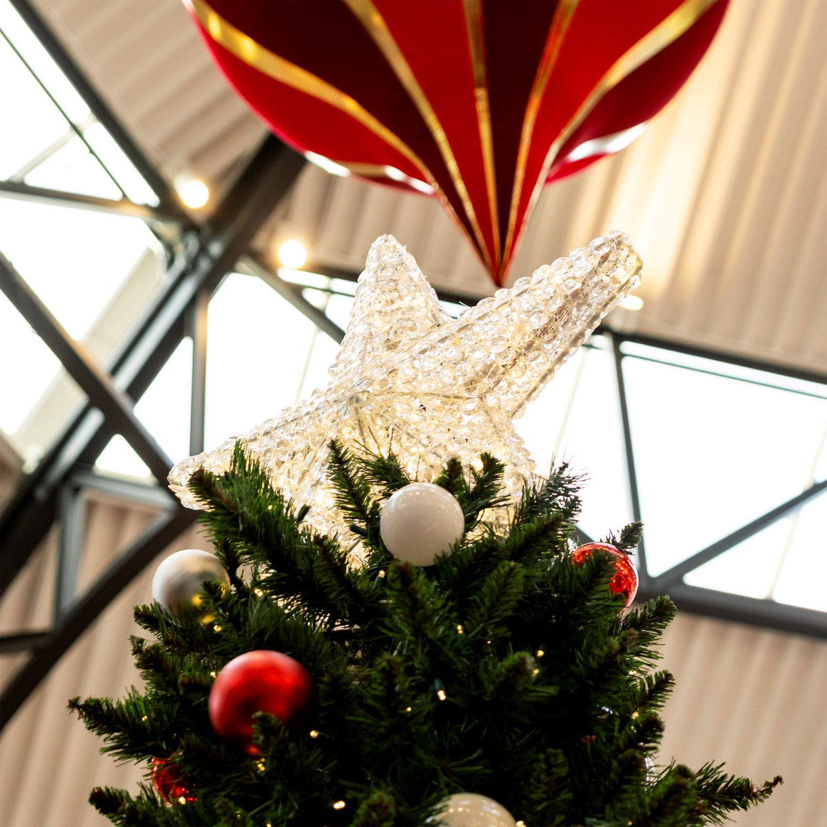 Dekra-Lite Warm White Crystal Star Tree Topper on a tree